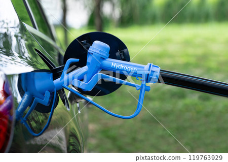 Close up of fuel cell car with connected hydrogen fueling nozzle. 119763929