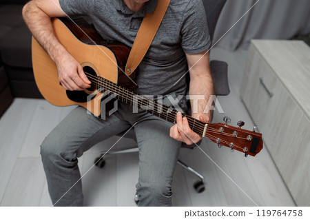 Guitarist on acoustic guitar playing melody in studio. Close up musician instrument 119764758