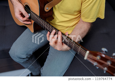 Guitarist on acoustic guitar playing melody in studio. Close up musician instrument 119764774