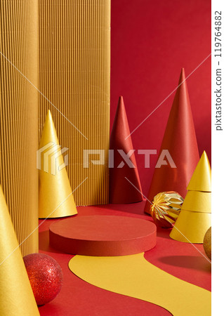 Red and yellow christmas template photo, cone blocks and decorative items placed around an empty showcase cylinder platform in center. High angle view, luxury style Red and yellow christmas template photo, cone blocks and decorative items placed around an empty showcase cylinder platform in center. High angle view, luxury style 119764882