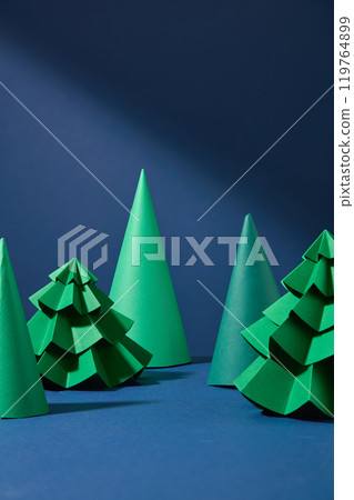 Green christmas trees and cone shape blocks standing out on blue background. Photo was taken from front view, vacant space for product displaying 119764899