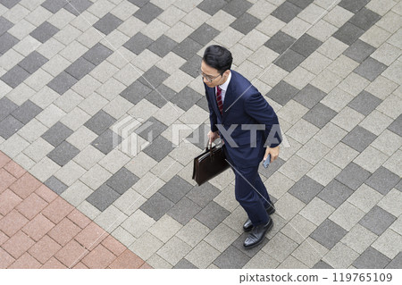 Aerial view of a middle-aged businessman walking in the city 119765109