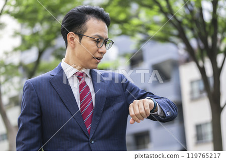 A businessman in his 40s looking at a smartwatch 119765217