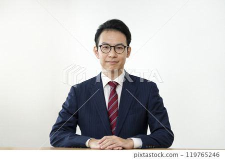 一位三十多歲的商人戴著眼鏡對著鏡頭微笑 一位三十多歲的商人戴著眼鏡對著鏡頭微笑 119765246