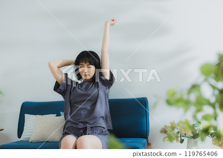 A young woman in loungewear stretching A young woman in loungewear stretching 119765406