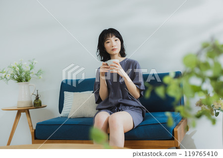 A young woman in loungewear stretching 119765410