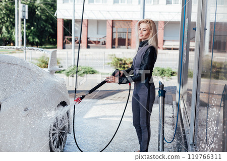 Female driver washing car at car wash Female driver washing car at car wash 119766311