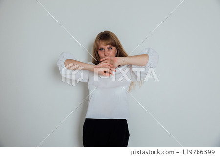Beautiful woman covers her mouth with her hands silent 119766399
