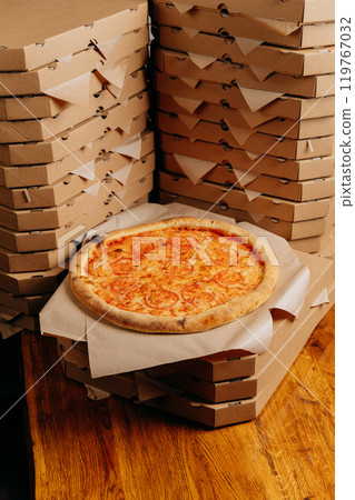 Stacked pizza boxes with a fresh pizza, ready for delivery or takeaway 119767032