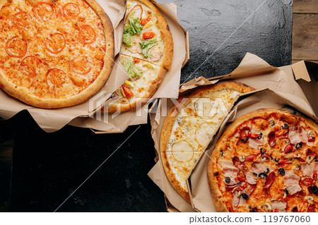 Assortment of delicious pizzas with various toppings, perfect for delivery or casual dining 119767060