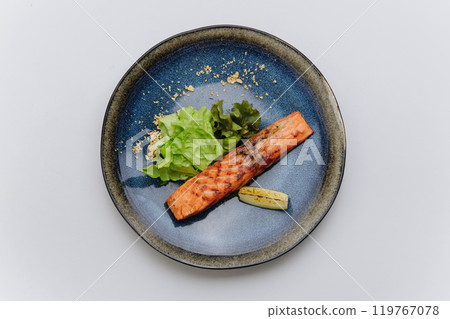 Grilled salmon fillet served with fresh salad and lemon, healthy and delicious dining moments Grilled salmon fillet served with fresh salad and lemon, healthy and delicious dining moments 119767078