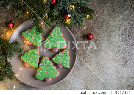 Christmas tree shaped gingerbread. Top view of plate with christmas cookies on gray background with copy space 119767335