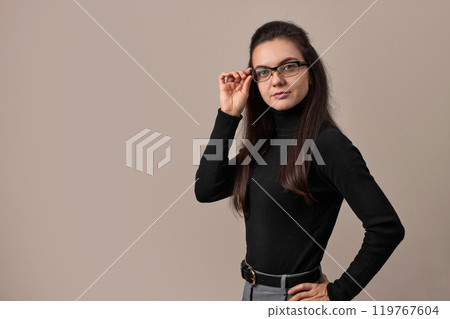 freelancer businesswoman lady wear eyeglasses and black sweater isolated on gray background, copy space freelancer businesswoman lady wear eyeglasses and black sweater isolated on gray background, copy space 119767604