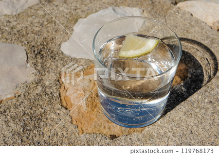 glass with sparkling water on a rustic surface 119768173