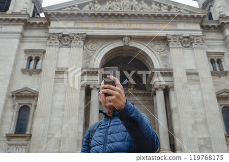 man in front of St Stephens Basilica in Budapest man in front of St Stephens Basilica in Budapest 119768175