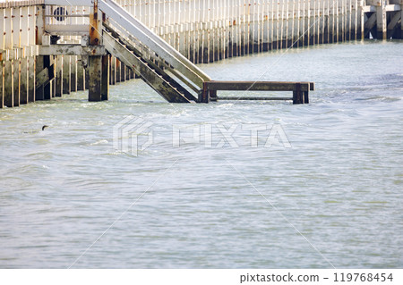 A Flooded Pier with Submerged Stairs Immersed in Calm and Tranquil Waters of Nature 119768454