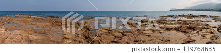 Panoramic View of Rocky Coastline with Distant Hills and Calm Sea Panoramic View of Rocky Coastline with Distant Hills and Calm Sea 119768635