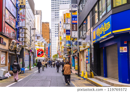 Tokyo cityscape in Japan: Shinjuku West Exit drinking district. People commuting to work in the office district in the back... = 21st 119769372