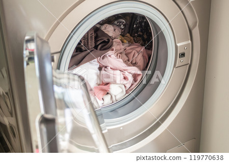 Washing machine loaded with clothes close up 119770638