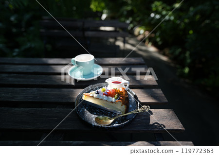 blue coffee cup and Dessert with coffee  Strawberry Cheesecake on grunge wooden table outdoor chilling 119772363