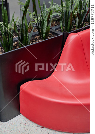 Vertical shot of common area in business center featuring greenery and designer seating in vibrant red color, copy space Vertical shot of common area in business center featuring greenery and designer seating in vibrant red color, copy space 119773711