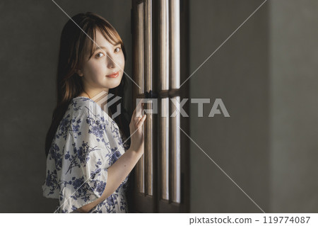 A woman by the window 119774087