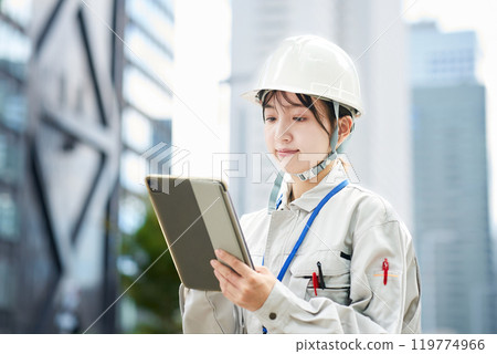 穿著工作服和頭盔的年輕女子 穿著工作服和頭盔的年輕女子 119774966
