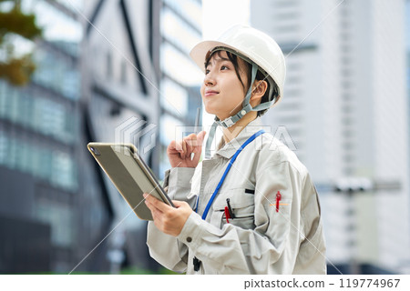 穿著工作服和頭盔的年輕女子 穿著工作服和頭盔的年輕女子 119774967