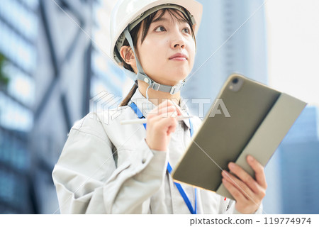 穿著工作服和頭盔的年輕女子 穿著工作服和頭盔的年輕女子 119774974
