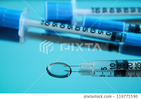 Injection syringes on a medical tray in bright turquoise color. Injection syringes on a medical tray in bright turquoise color. 119775590