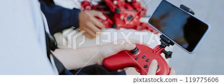 Website banner with unrecognizable girl holding red plastic joystick with smartphone Website banner with unrecognizable girl holding red plastic joystick with smartphone 119775606