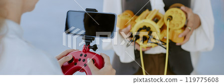 Website banner of unrecognizable girl holding red joystick with set smartphone 119775608