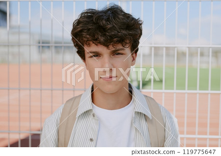 Medium close up of curly haired Caucasian teen boy dressed in casual clothes Medium close up of curly haired Caucasian teen boy dressed in casual clothes 119775647