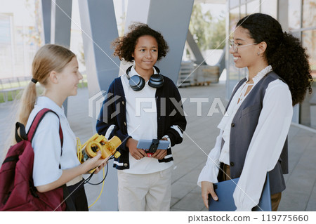 Biracial students with robots in hands thanking female teacher for open air robotics lesson Biracial students with robots in hands thanking female teacher for open air robotics lesson 119775660
