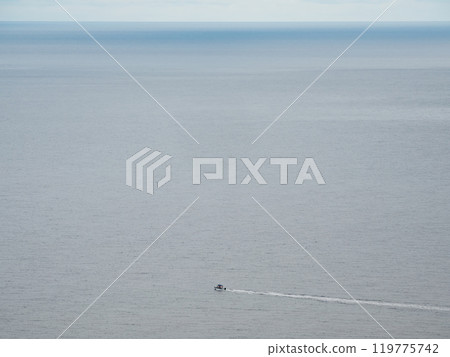 Small white boat sailing in the blue sea. Small white boat sailing in the blue sea. 119775742