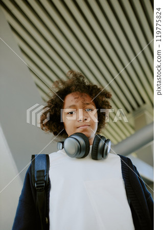 Low angle portrait of modern teen dressed in casual outfit looking directly in camera 119775824