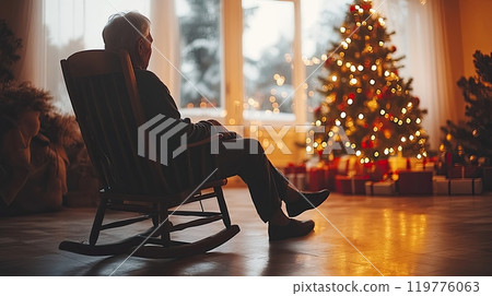 an elderly person, alone in welcoming house on Christmas, sitting in a rocking chair by the tree  119776063