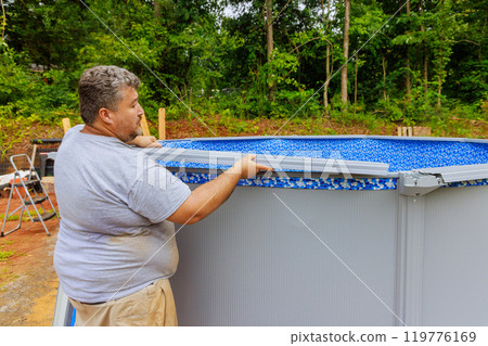 Installation of construction ground swimming pool in backyard of house 119776169