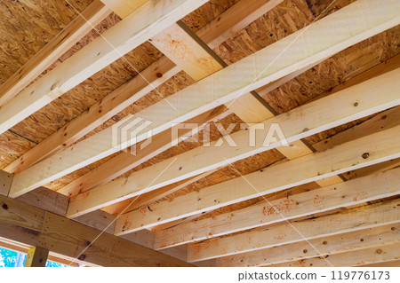 During construction of new home, wooden frame beams are used to frame roofing trusses During construction of new home, wooden frame beams are used to frame roofing trusses 119776173