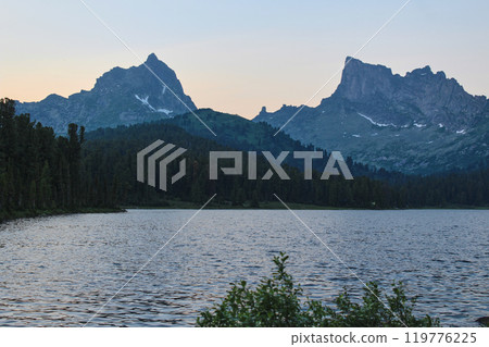 Two rocky peaks in the mountains and big mountain lake at dusk Two rocky peaks in the mountains and big mountain lake at dusk 119776225