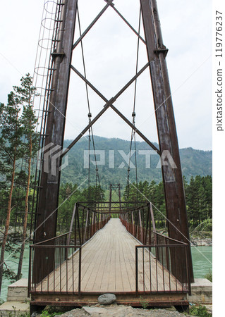iron suspension bridge for pedestrians across the river iron suspension bridge for pedestrians across the river 119776237