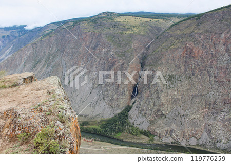 View from Katu-Yaryk pass to Chulyshman valley. High mountains with a waterfall, a river and a recreation center below View from Katu-Yaryk pass to Chulyshman valley. High mountains with a waterfall, a river and a recreation center below 119776259
