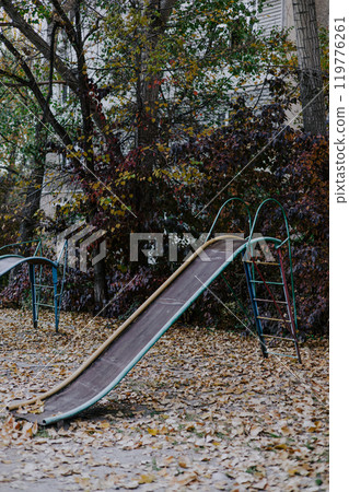 Old unsafe metal multi-colored children's slide. Equipment in kindergarten. Old unsafe metal multi-colored children's slide. Equipment in kindergarten. 119776261