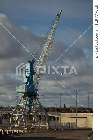 blue port crane on a background of blue sky with clouds. 119777619