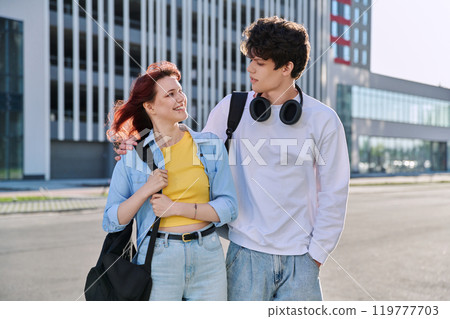 Teenage college students guy and girl talking, standing outdoor, urban style Teenage college students guy and girl talking, standing outdoor, urban style 119777703