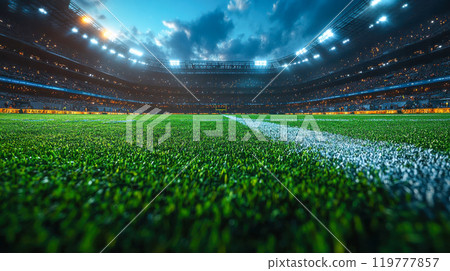 Close-up view of a football field with stadium lights illuminating the rain-kissed grass, creating an intense game atmosphere 119777857