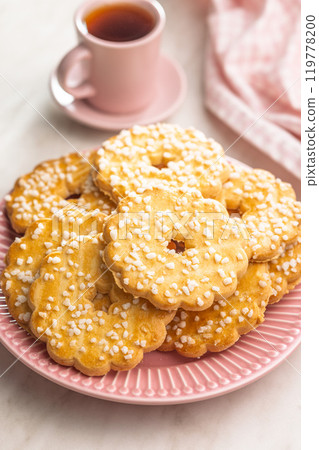 Sweet cookies in the shape of a flower. Tasty biscuits on plate on white table. 119778200