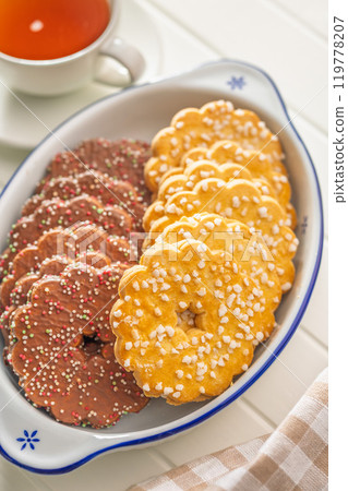 Sweet cookies in the shape of a flower. Tasty biscuits in bowl on white table. 119778207