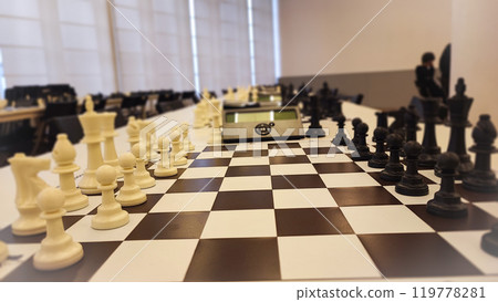 An empty hall with tables on which chess boards and timers are prepared. Concept of competition sport chess, leadership skills, self-development. An empty hall with tables on which chess boards and timers are prepared. Concept of competition sport chess, leadership skills, self-development. 119778281