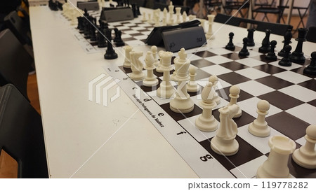 An empty hall with tables on which chess boards and timers are prepared. Concept of competition sport chess, leadership skills, self-development. 119778282